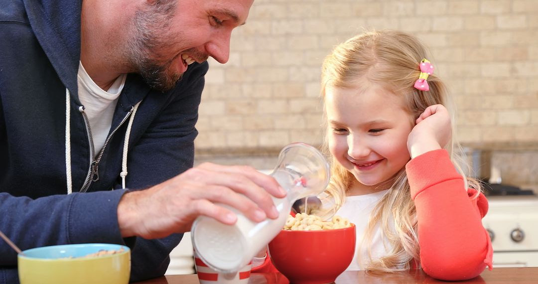 Father Pouring Milk into Daughter's Cereal Bowl at Breakfast Table - Free Images, Stock Photos and Pictures on Pikwizard.com