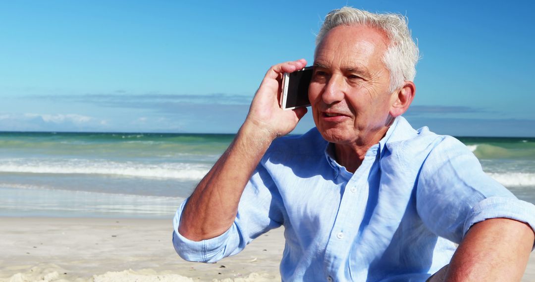 Senior Man Relaxing on Beach Talking on Smartphone  - Free Images, Stock Photos and Pictures on Pikwizard.com