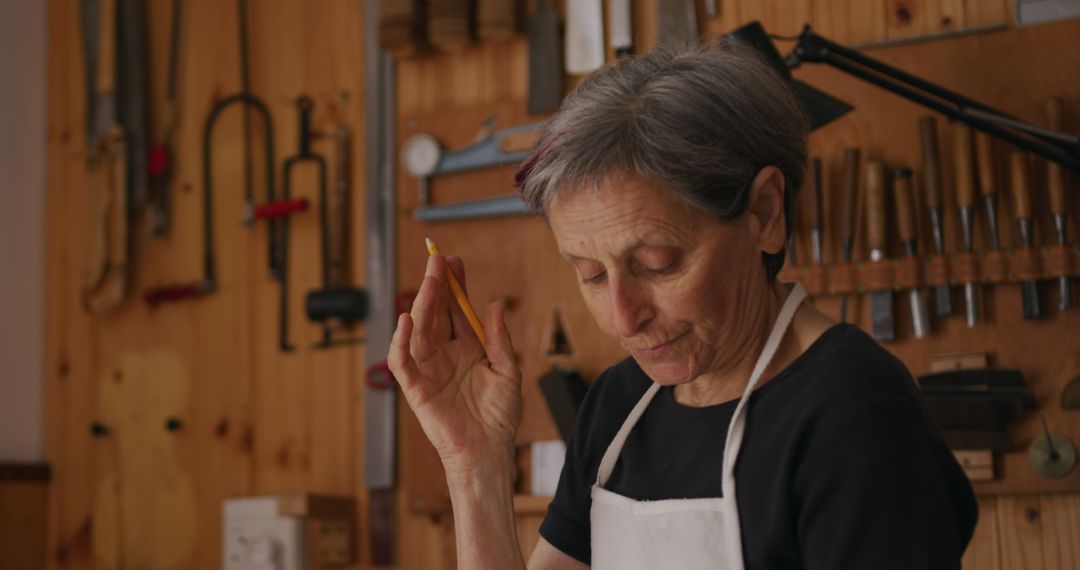 Senior Woman Carpenter with Pencil in Wood Workshop - Free Images, Stock Photos and Pictures on Pikwizard.com