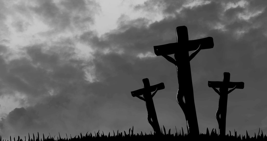 Silhouette of three crosses against cloudy sky in black and white