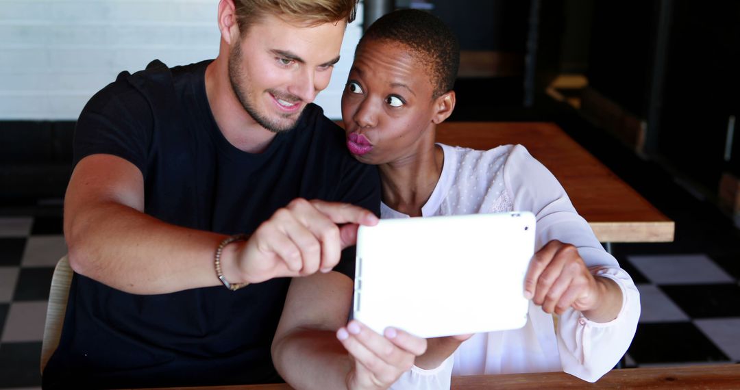 Playful Friends Taking Selfie with Tablet at Cafe - Free Images, Stock Photos and Pictures on Pikwizard.com