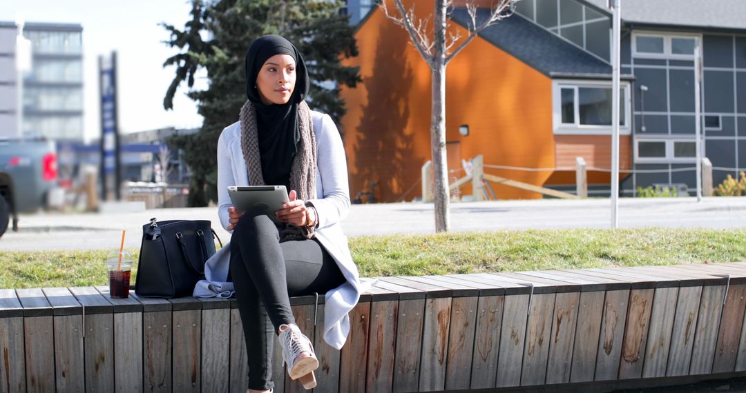 Muslim Woman Outdoors with Tablet at Urban Setting - Free Images, Stock Photos and Pictures on Pikwizard.com