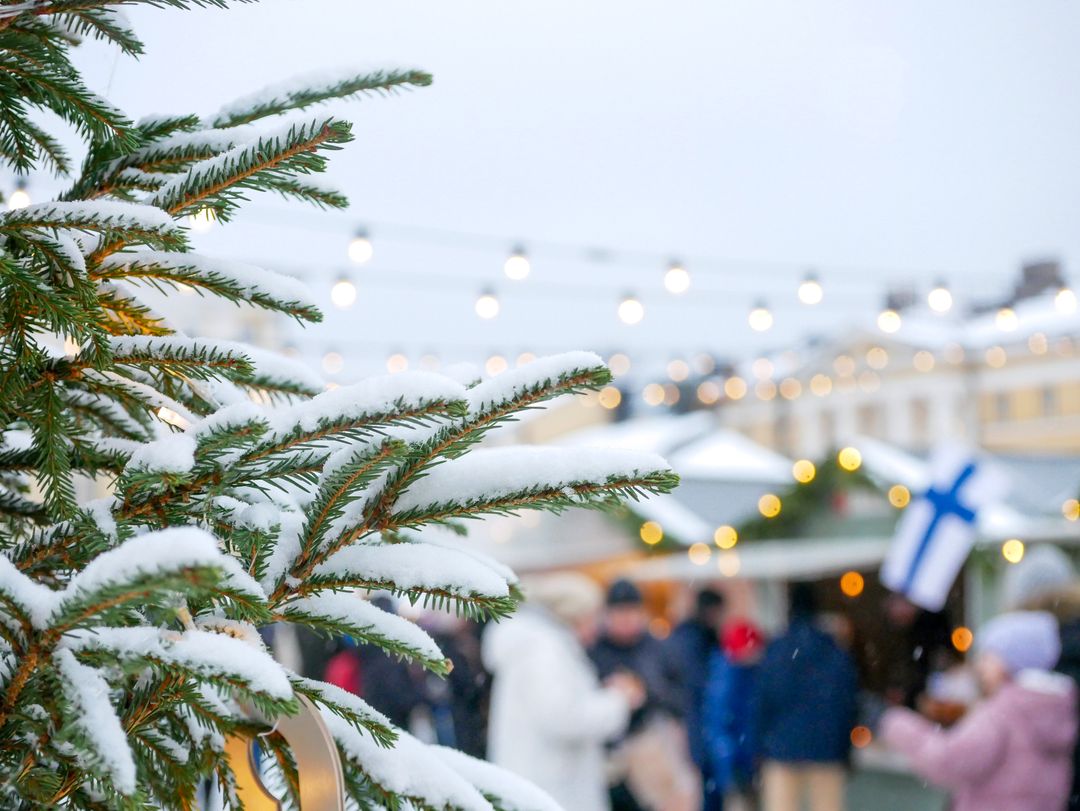 Festive Christmas Market with Snow-Covered Tree Branch