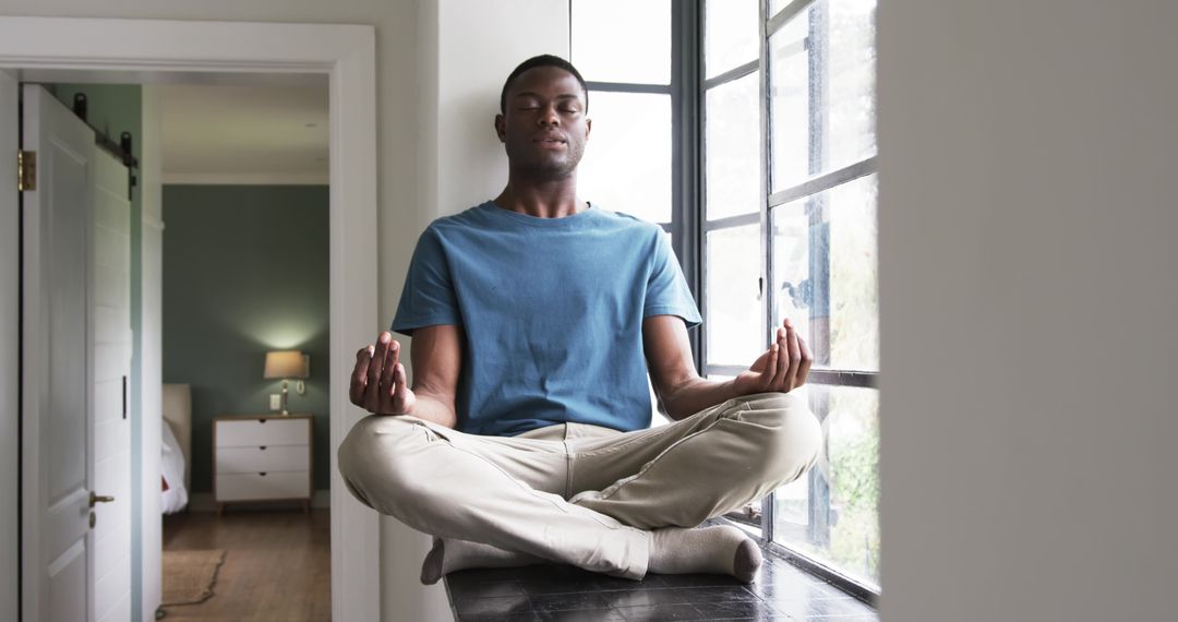 Man Meditating Peacefully by Window Embracing Serenity