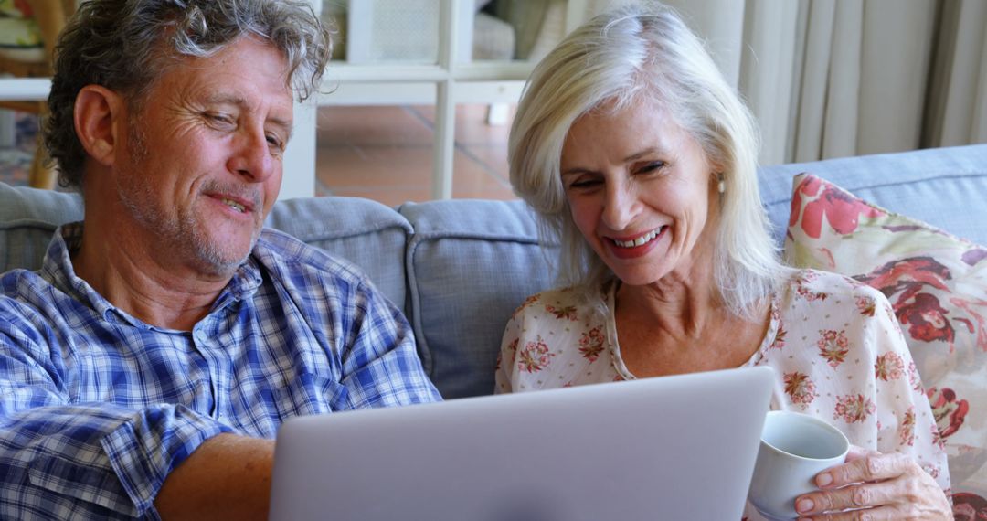 Happy Senior Couple Using Laptop at Home