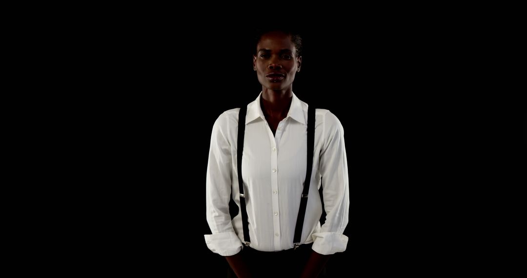 Confident Young Woman in White Shirt with Suspenders Against Black Background - Free Images, Stock Photos and Pictures on Pikwizard.com