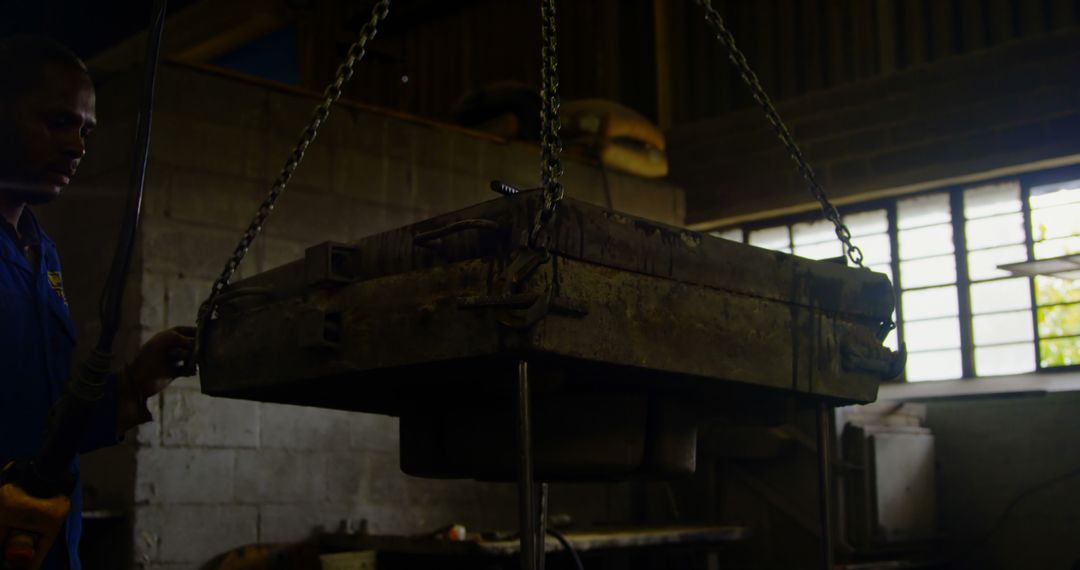 Worker Operating Overhead Crane with Heavy Mold in Industrial Workshop