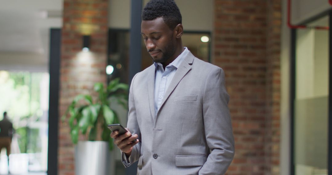 Confident Businessman Checking Smartphone in Office - Free Images, Stock Photos and Pictures on Pikwizard.com