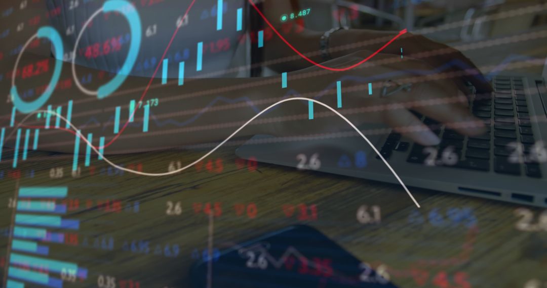 Analyzing Financial Data on Laptop with Overlayed Stock Charts - Free Images, Stock Photos and Pictures on Pikwizard.com