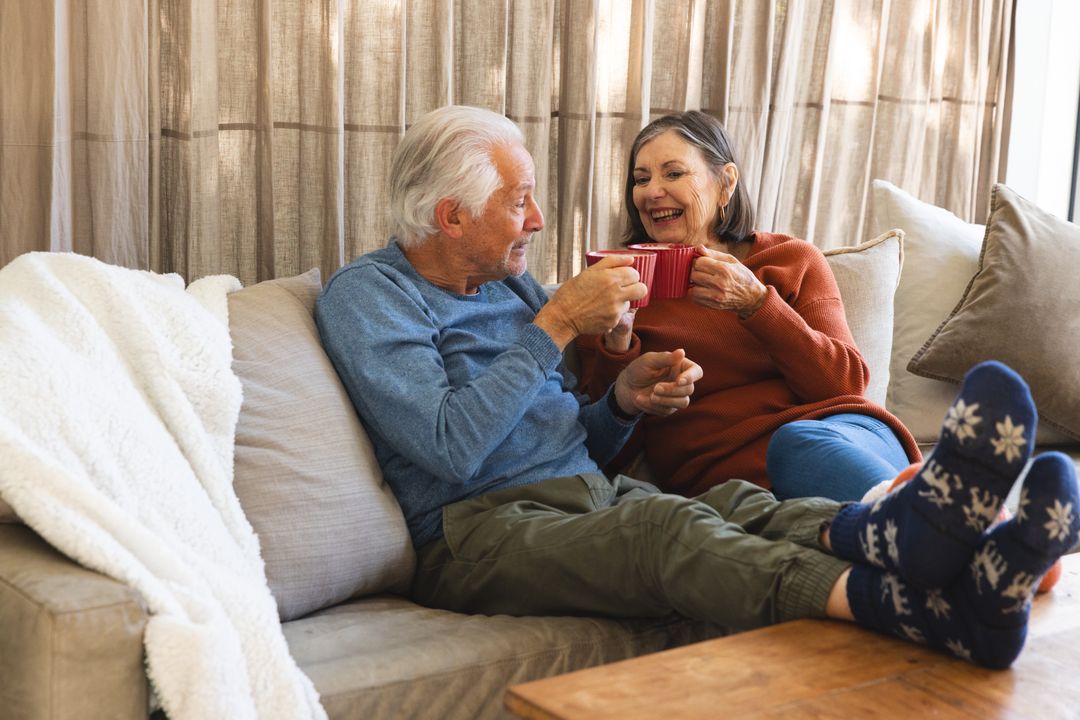 Senior Couple Drinking Coffee Relaxing on Comfortable Sofa