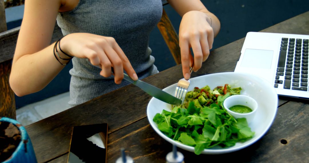 Woman Eating Fresh Salad While Working on Laptop - Free Images, Stock Photos and Pictures on Pikwizard.com