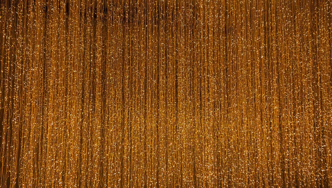 Shimmering Golden Curtain of Vertical String Lights Creating Warm Ambient Backdrop