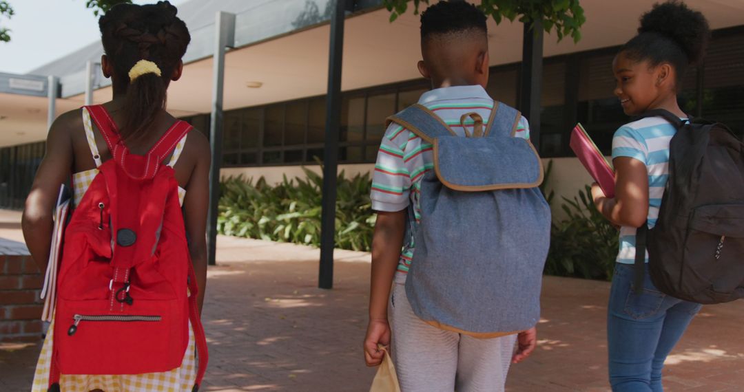 Schoolchildren Joyful in Courtyard with Backpacks