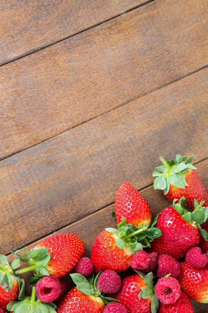 Fresh strawberries and raspberries on wooden board - Free Images, Stock Photos and Pictures on Pikwizard.com