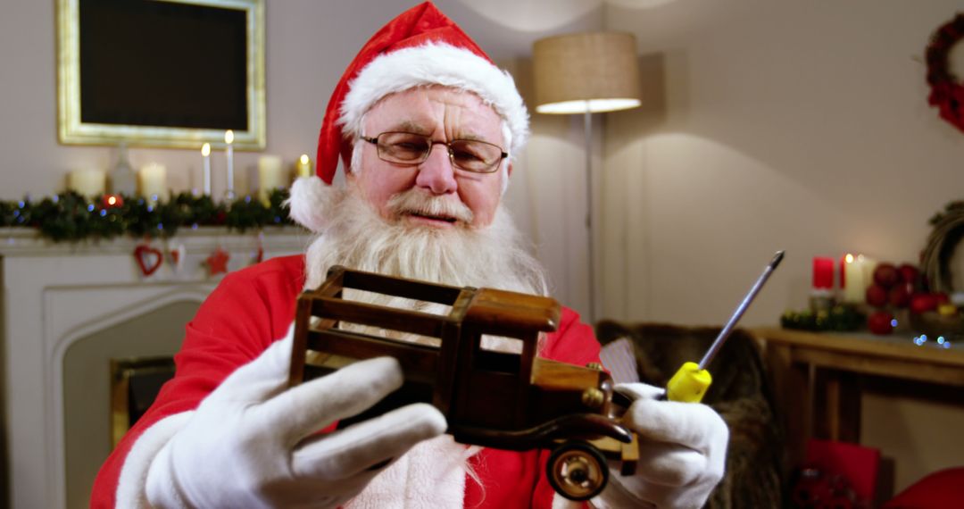 Santa Claus repairing wooden toy truck at home for Christmas - Free Images, Stock Photos and Pictures on Pikwizard.com