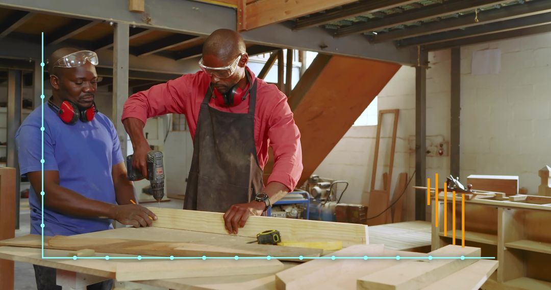 Carpentry team drilling wooden plank in workshop wearing safety goggles and ear protection