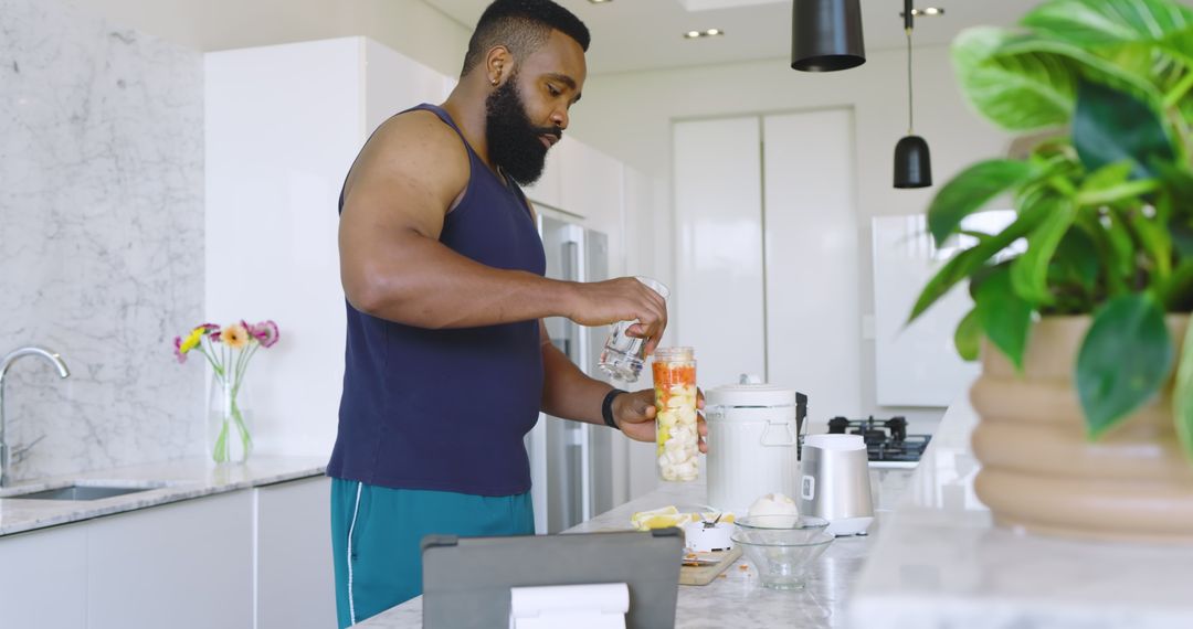 Man Preparing Healthy Smoothie with Fresh Fruits in Modern Kitchen