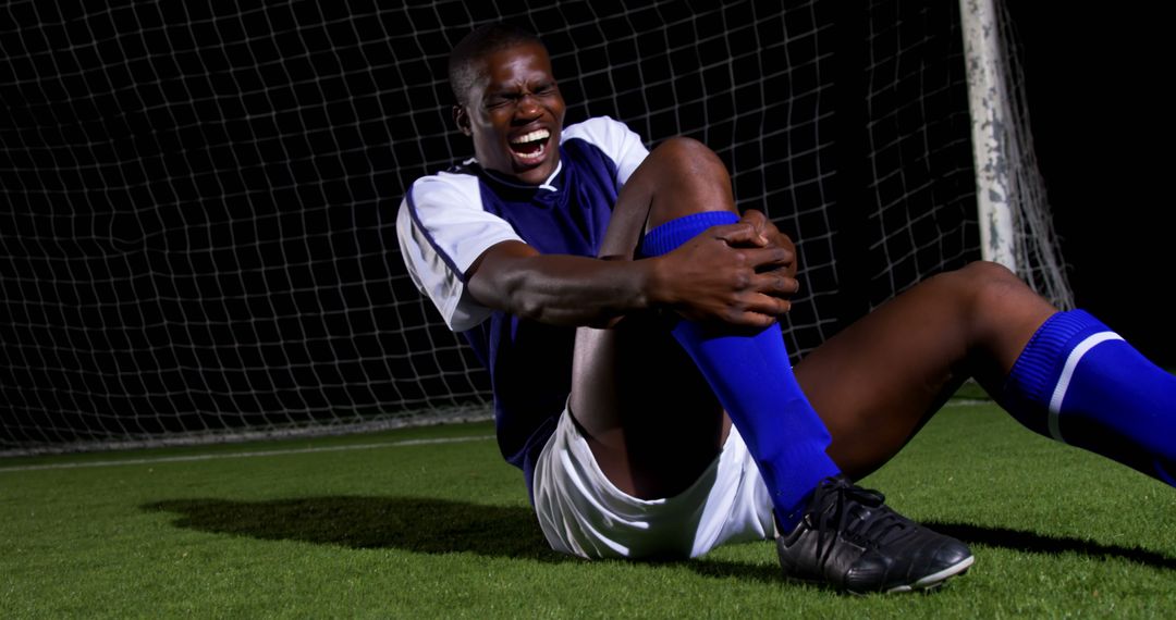 Injured Soccer Player on Field Holding Leg in Pain - Free Images, Stock Photos and Pictures on Pikwizard.com