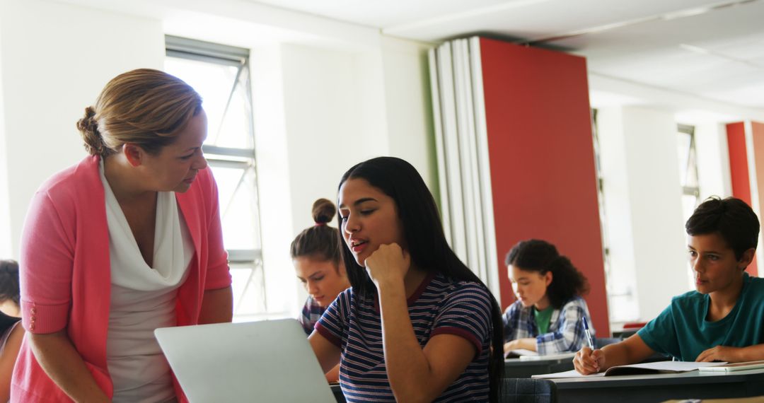 Teacher Assisting Student in Engaging Classroom Environment