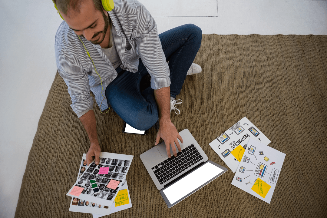 Creative Designer Reviewing Transparent Collage with Laptop on Rug