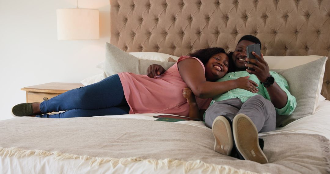 Couple Enjoying Tech and Relaxation in Bedroom Ambiance