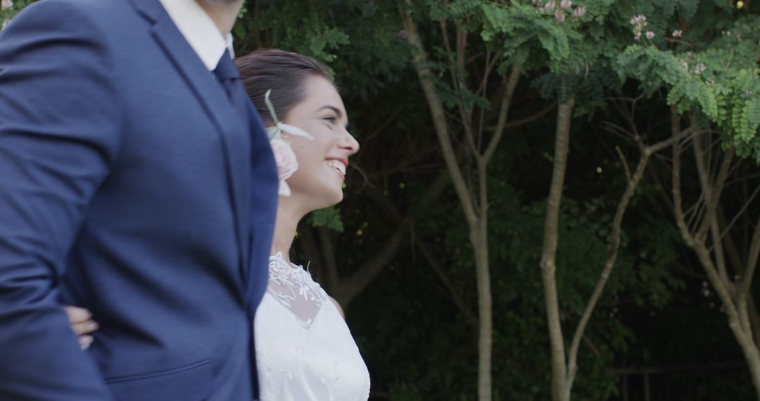 Bride Joyfully Walking Arm in Arm with Groom Outdoors