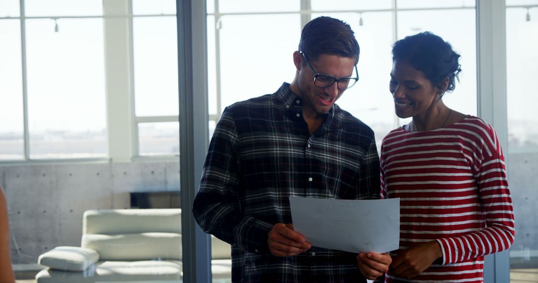Diverse Colleagues Examining Document in Sunlit Office