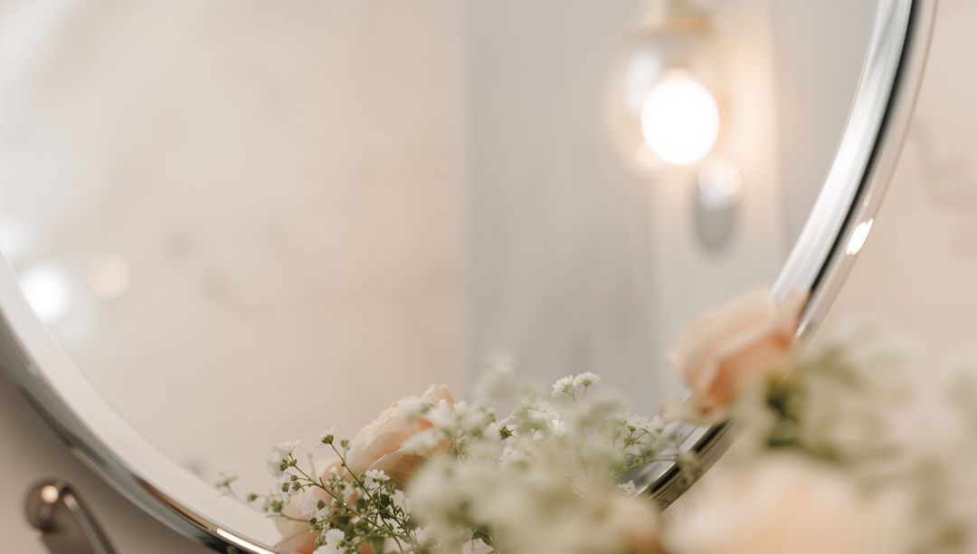 Soft Vanity Mirror Reflecting Warm Light and Pale Peach Roses for Romantic Ambiance
