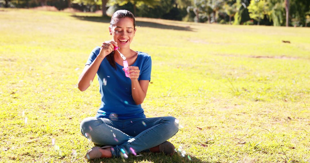 Young Woman Blowing Bubbles Outdoors in Park on Sunny Day - Free Images, Stock Photos and Pictures on Pikwizard.com