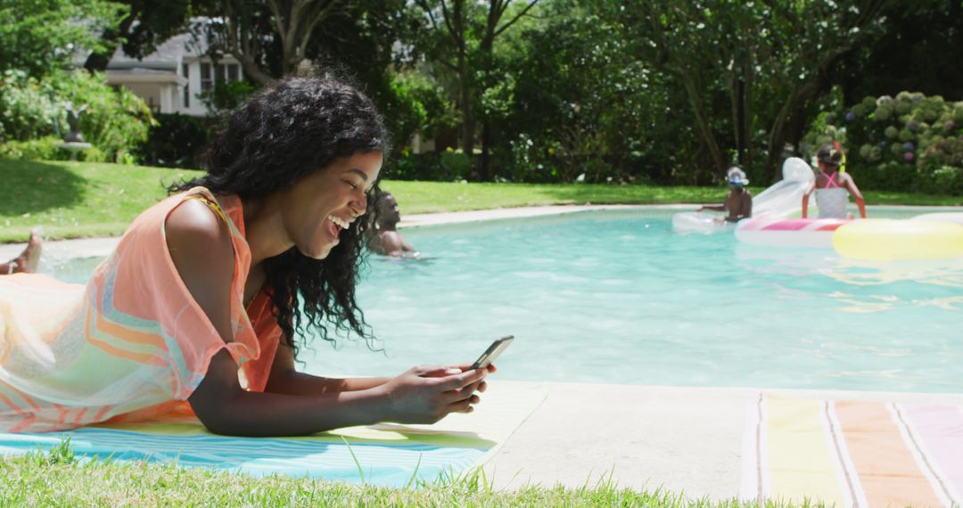 Happy african american woman relaxing at pool with family, using smartphone - Free Images, Stock Photos and Pictures on Pikwizard.com