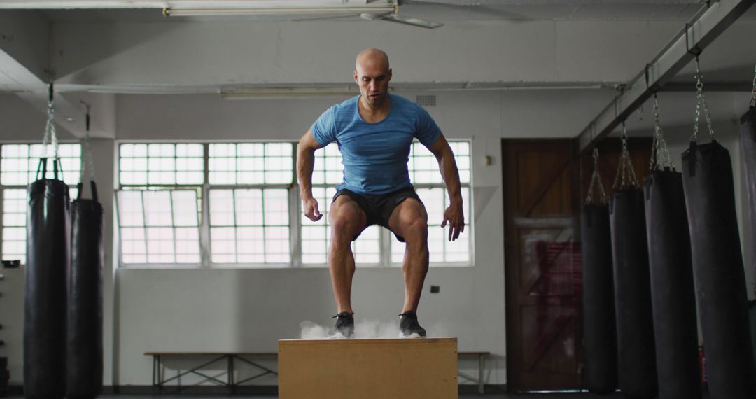 Fit caucasian man jumping on pylo box at the gym - Free Images, Stock Photos and Pictures on Pikwizard.com