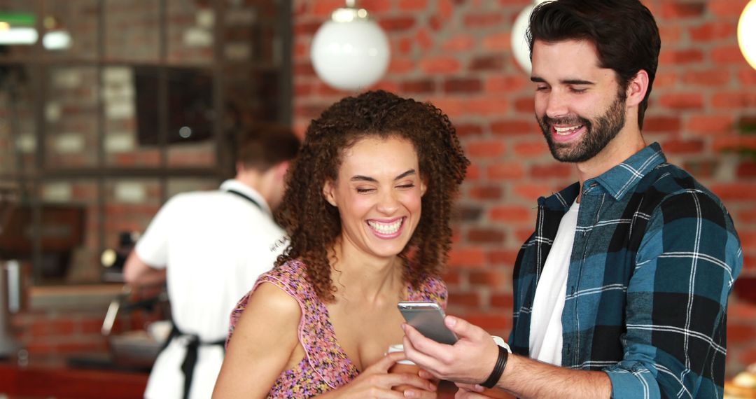 Friends Smiling and Sharing Smartphone Moment Indoors