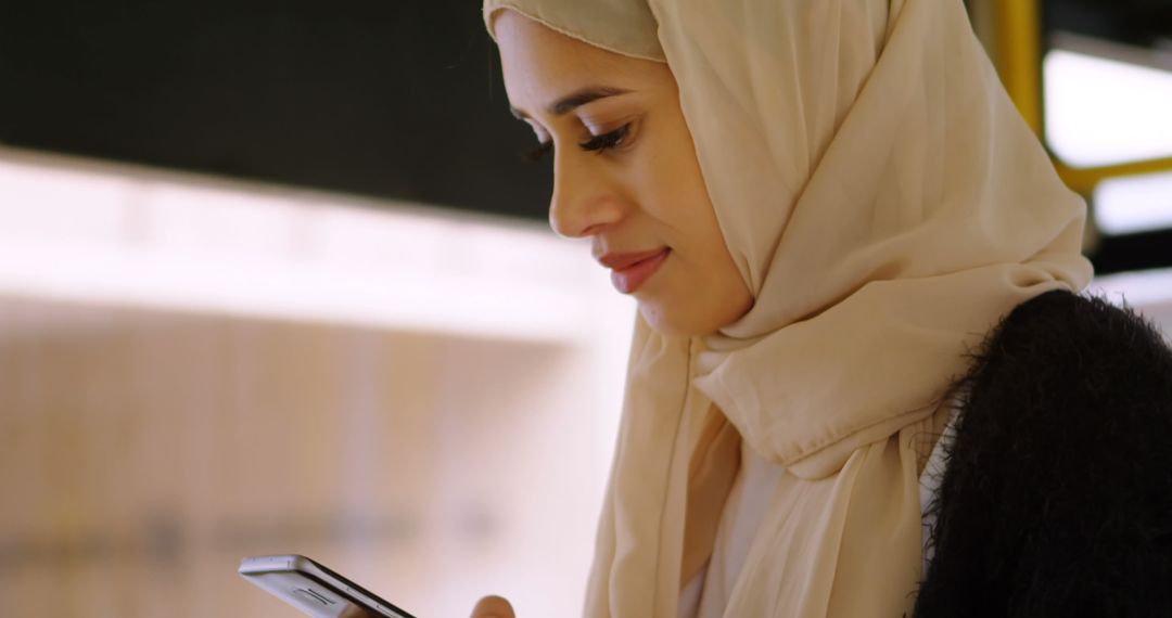 Smiling Woman in Hijab Using Smartphone Outside