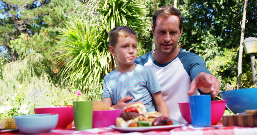 Family Picnic Father and Son Enjoying Outdoor Meal in Summer Garden - Free Images, Stock Photos and Pictures on Pikwizard.com