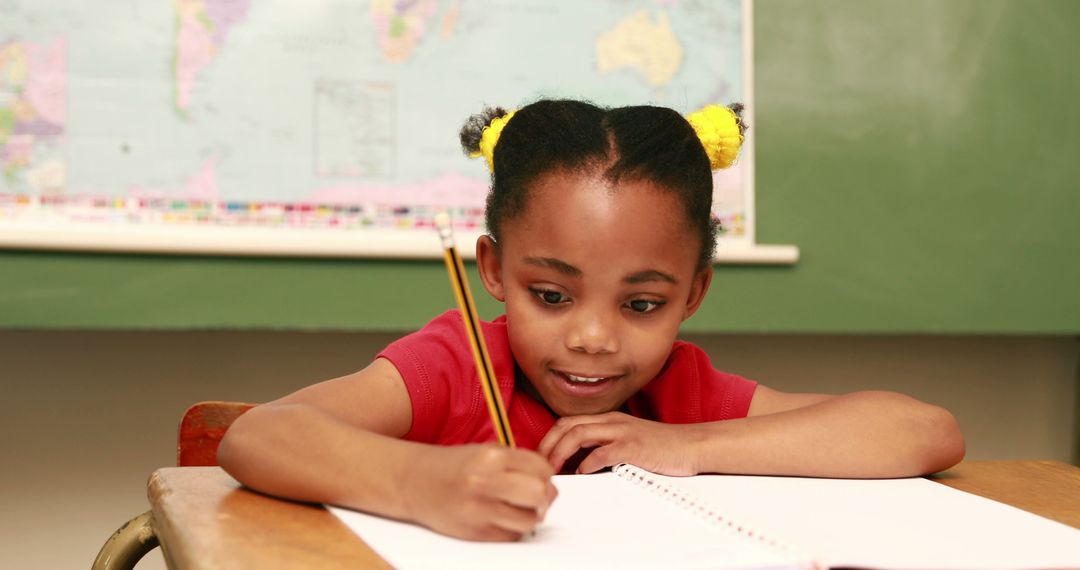 Young Black Girl Writing Schoolwork at Desk in Classroom Setting - Free Images, Stock Photos and Pictures on Pikwizard.com