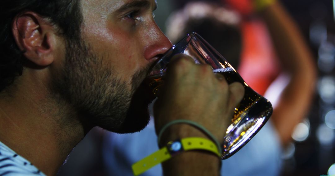 Young Man Enjoying Beverage from Glass Mug at Social Event - Free Images, Stock Photos and Pictures on Pikwizard.com