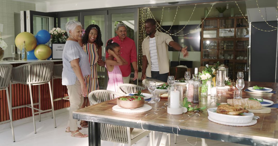Multigenerational family celebrating retirement on patio with string lights at dining table