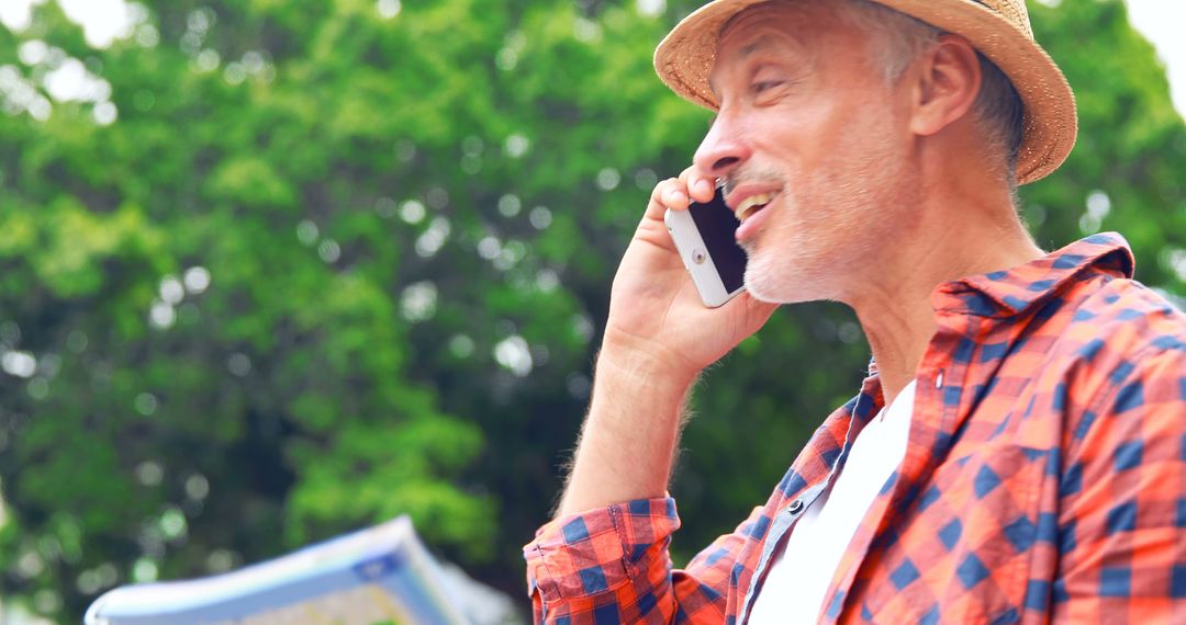 Smiling Mature Man in Hat Talking on Phone Outdoors - Free Images, Stock Photos and Pictures on Pikwizard.com