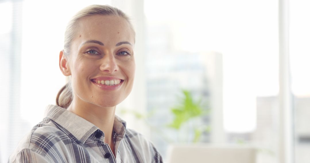 Smiling Businesswoman in Modern Office with Natural Light - Free Images, Stock Photos and Pictures on Pikwizard.com