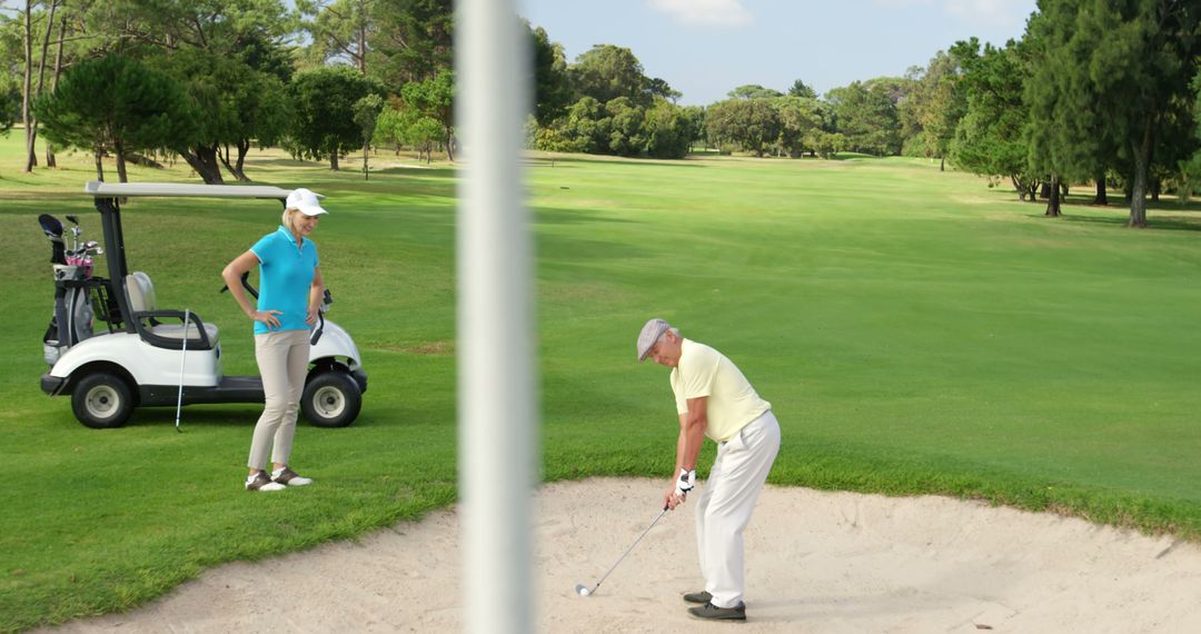 Senior Man Hitting Golf Ball from Sand Bunker on Sunny Day - Free Images, Stock Photos and Pictures on Pikwizard.com