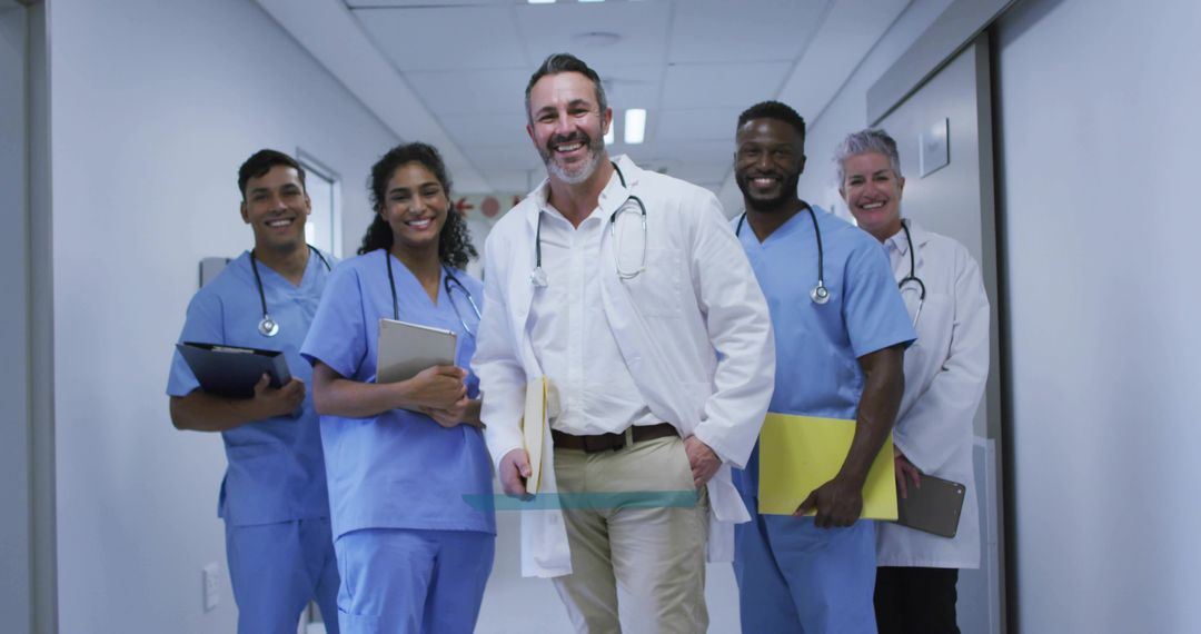 Smiling Multicultural Medical Team Walking Confidently in Hospital Corridor With Stethoscopes