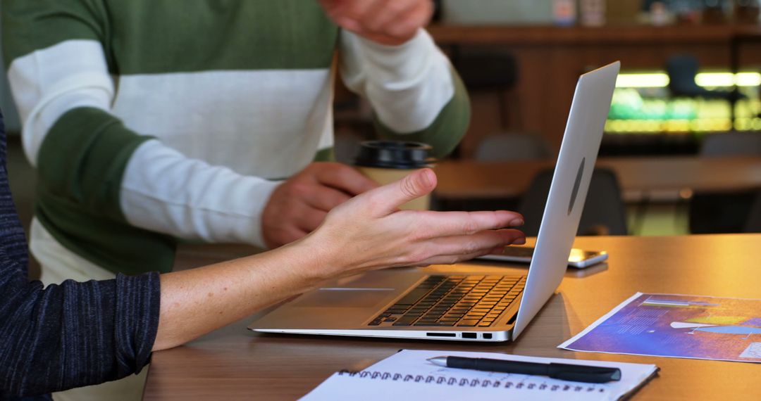 Colleagues Collaborating on Laptop in Casual Coffee Shop Setting