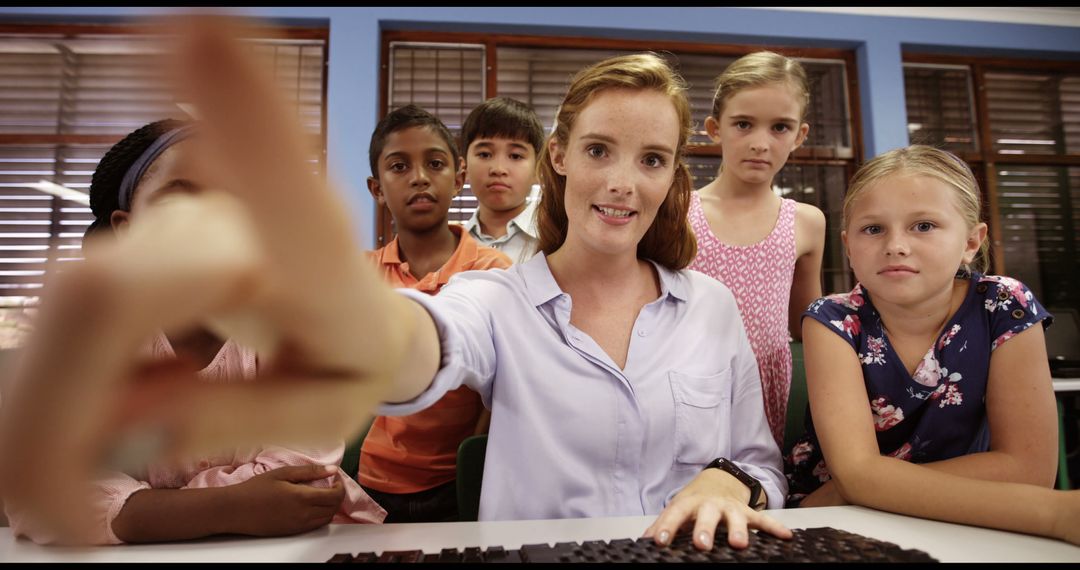 Teacher Helping Group of Students on Computer in Classroom