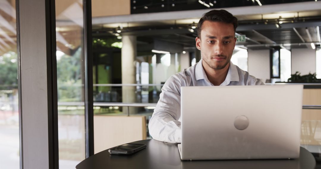 Professional Man Working on Laptop in Modern Office Lounge
