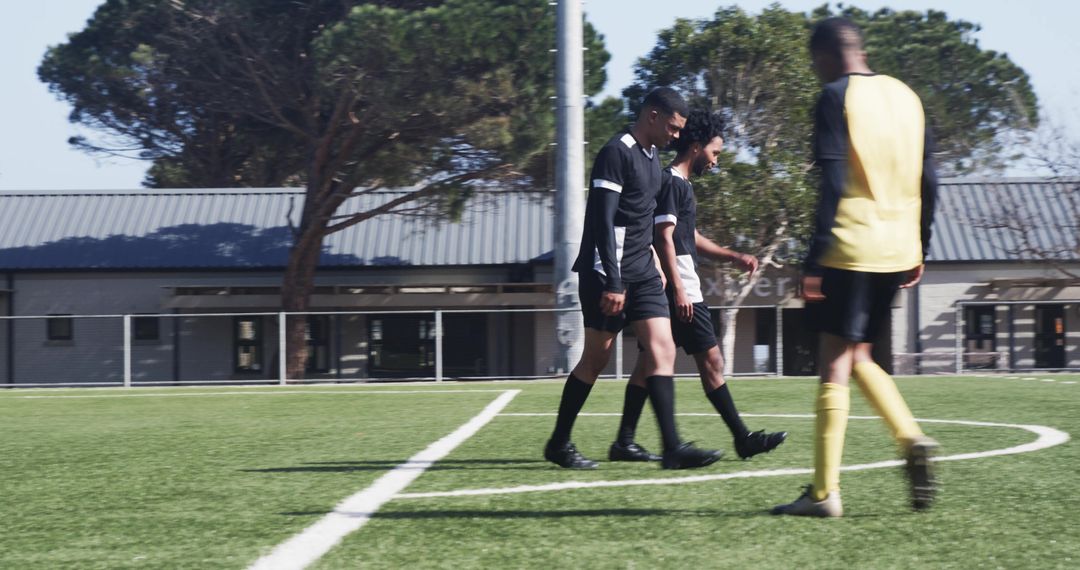 Soccer Players Strategizing on Clear Day in Outdoor Field