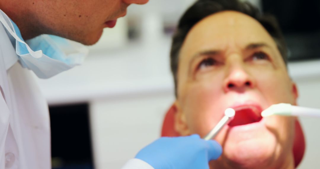 Dentist Treating Senior Male Patient in Dental Clinic - Free Images, Stock Photos and Pictures on Pikwizard.com