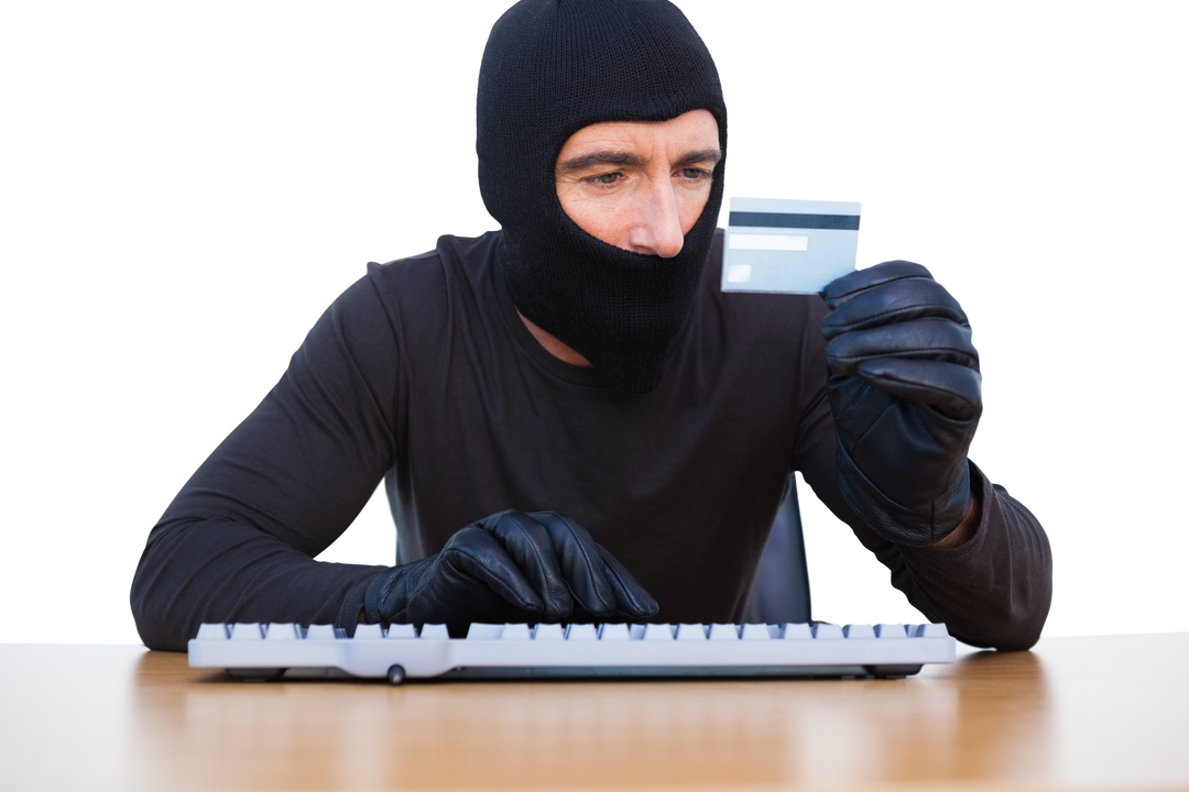 Masked Hacker in Black examining Credit Card and coding on Keyboard, Transparent Background - Download Free Stock Images Pikwizard.com