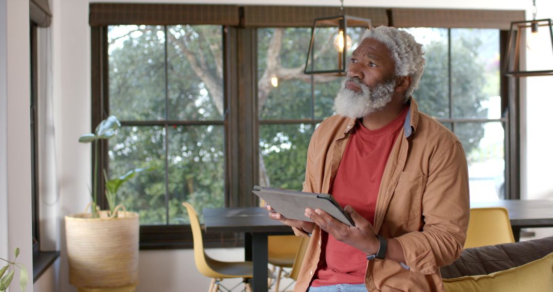 Senior Man Using Tablet in Relaxed Home Environment