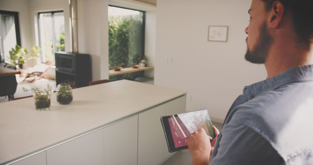 Man Using Tablet for Smart Home Control in Modern Kitchen