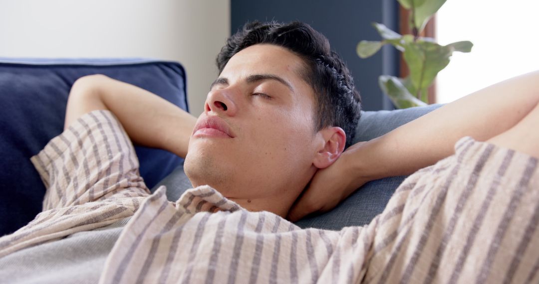 Man Relaxing on Couch Resting with Eyes Closed